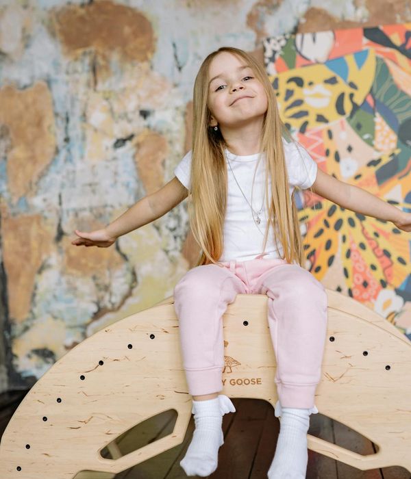 Joyful child in a playful yoga pose, smiling.